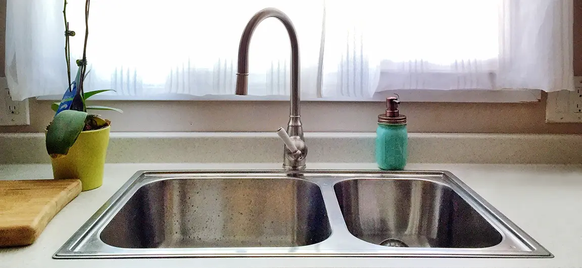 A dirty stainless steel kitchen sink.