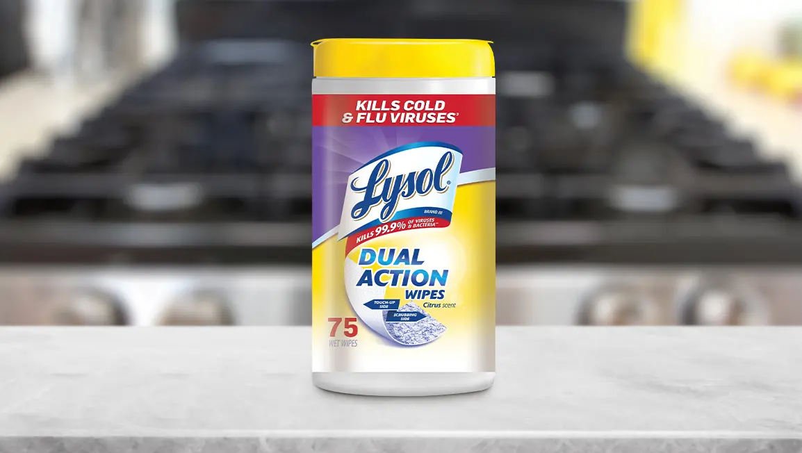 A canister of Lysol Dual Action Disinfecting Wipes resting on a kitchen counter. An oven is in the background.