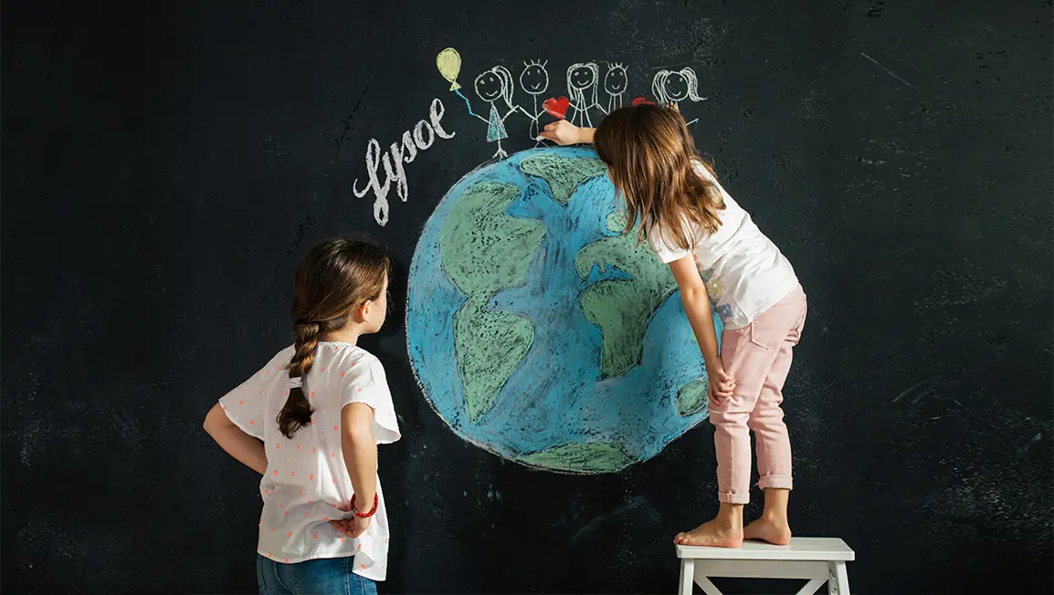 Children drawing the planet earth on a chalkboard. Stick figures are holding hands and smiling on top of the earth next to the word "Lysol"