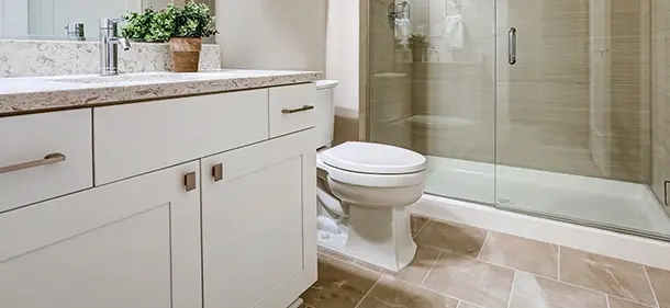 A bathroom featuring a sink vanity, toilet and shower.