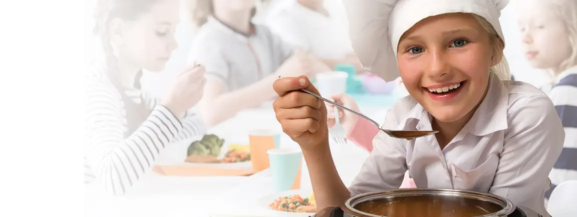 Child in chef hat holding spoon over pot