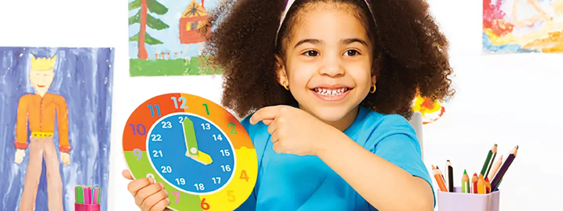 Child pointing at colorful clock they are holding up