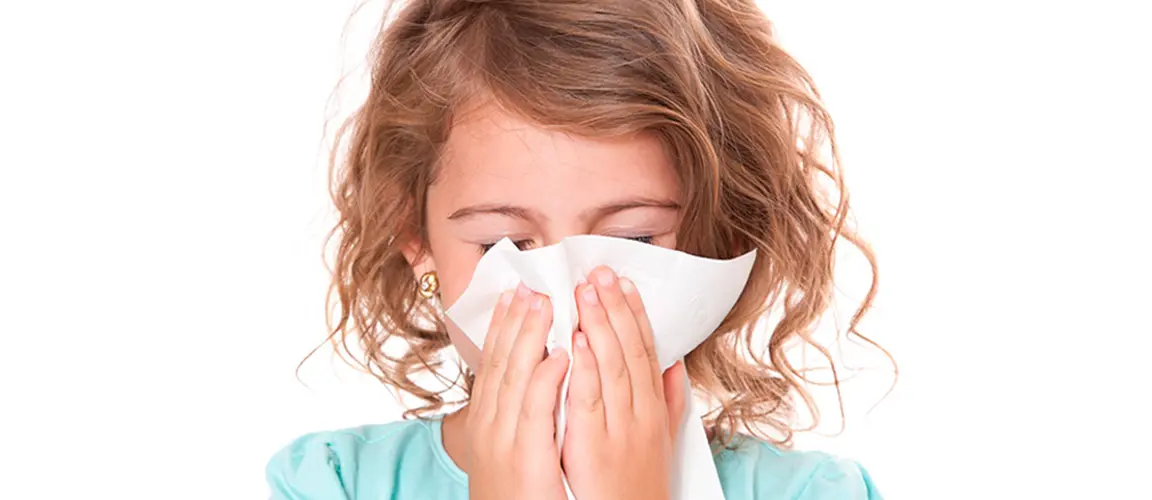 Child sneezing into tissue