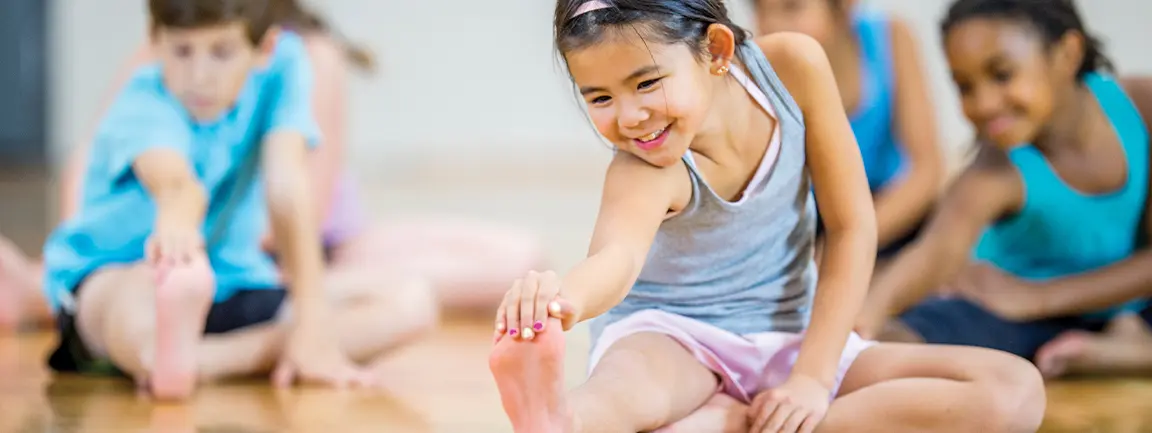 Young Smiling Preteen Girl Doing Gymnastics Stretching Exercises