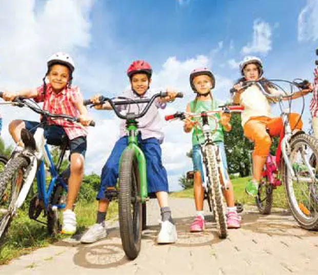 Four children on bikes standing on path facing the camera