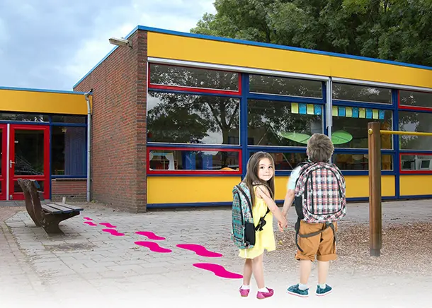 Kids with backpacks heading into a school with pink footprints leading up to the door