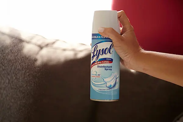 Person spraying Lysol Disinfectant Spray into the air