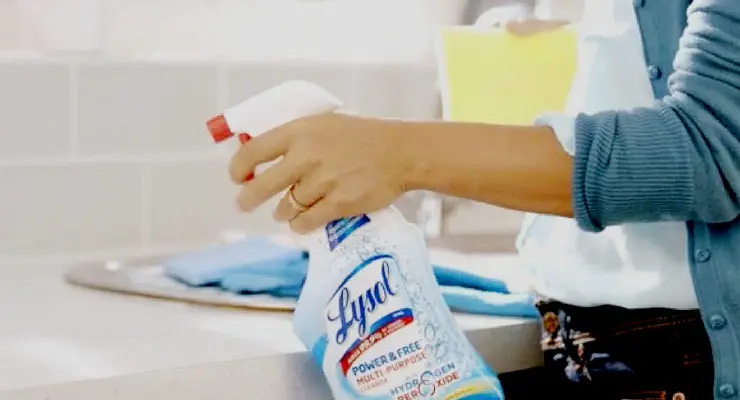 Person holding Lysol Multi Purpose Cleaner with Hydrogen Peroxide towards a kitchen counter
