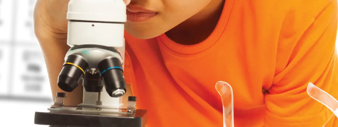 Child peering into microscope