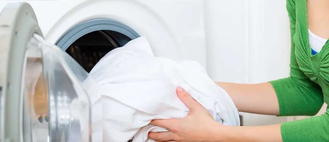 Adult placing soiled linen into washing machine