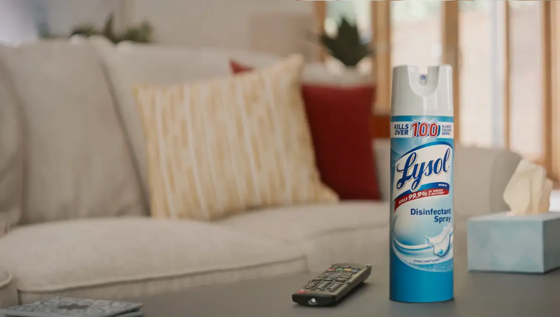A hand spraying Lysol Disinfecting Spray into the air