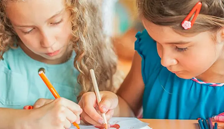 Two children draw on the same sheet of paper