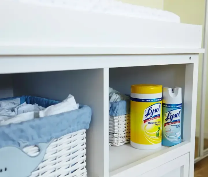 Cabinet with baskets containing diapers and canisters of Lysol Disinfecting Wipes and Lysol Disinfectant Spray