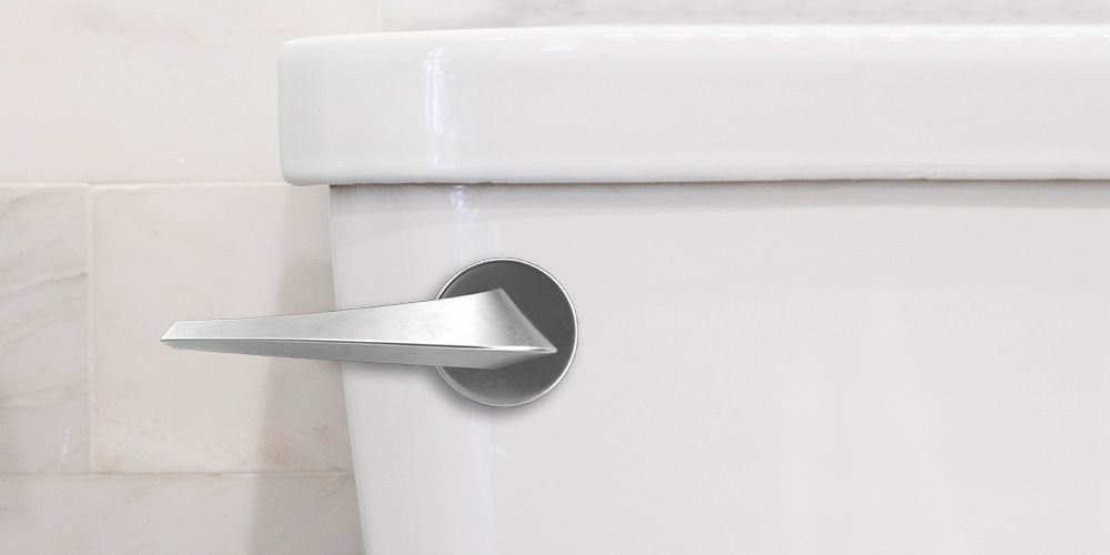 Close-up of a white toilet tank with a silver handle.